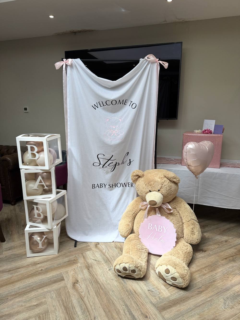 Draped backdrop with teddy bear and balloon baby blocks for a baby shower