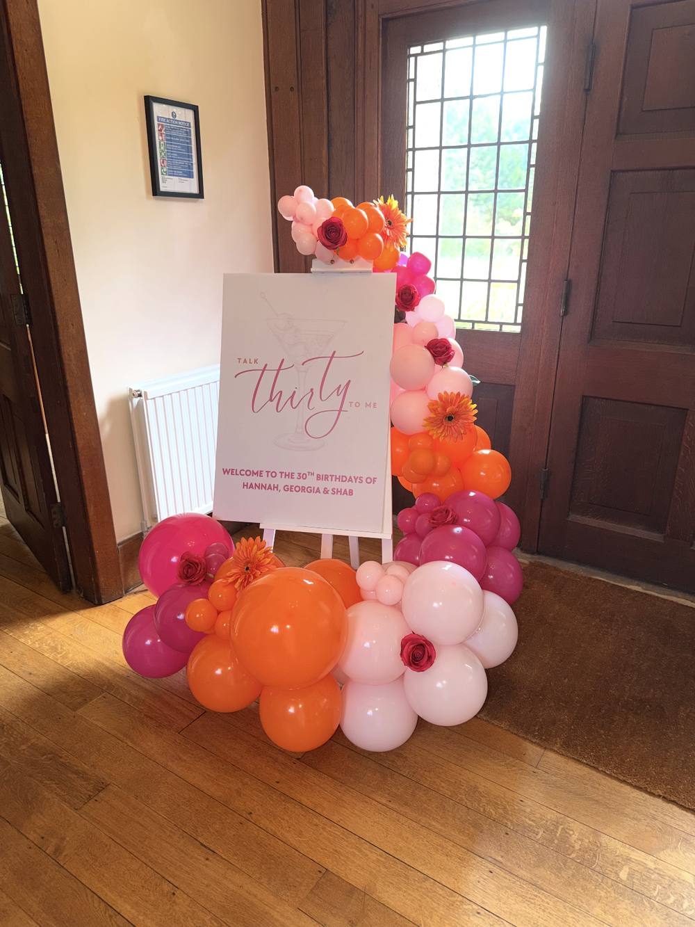 Easel display with personalised sign and balloon garland for a 30th birthday