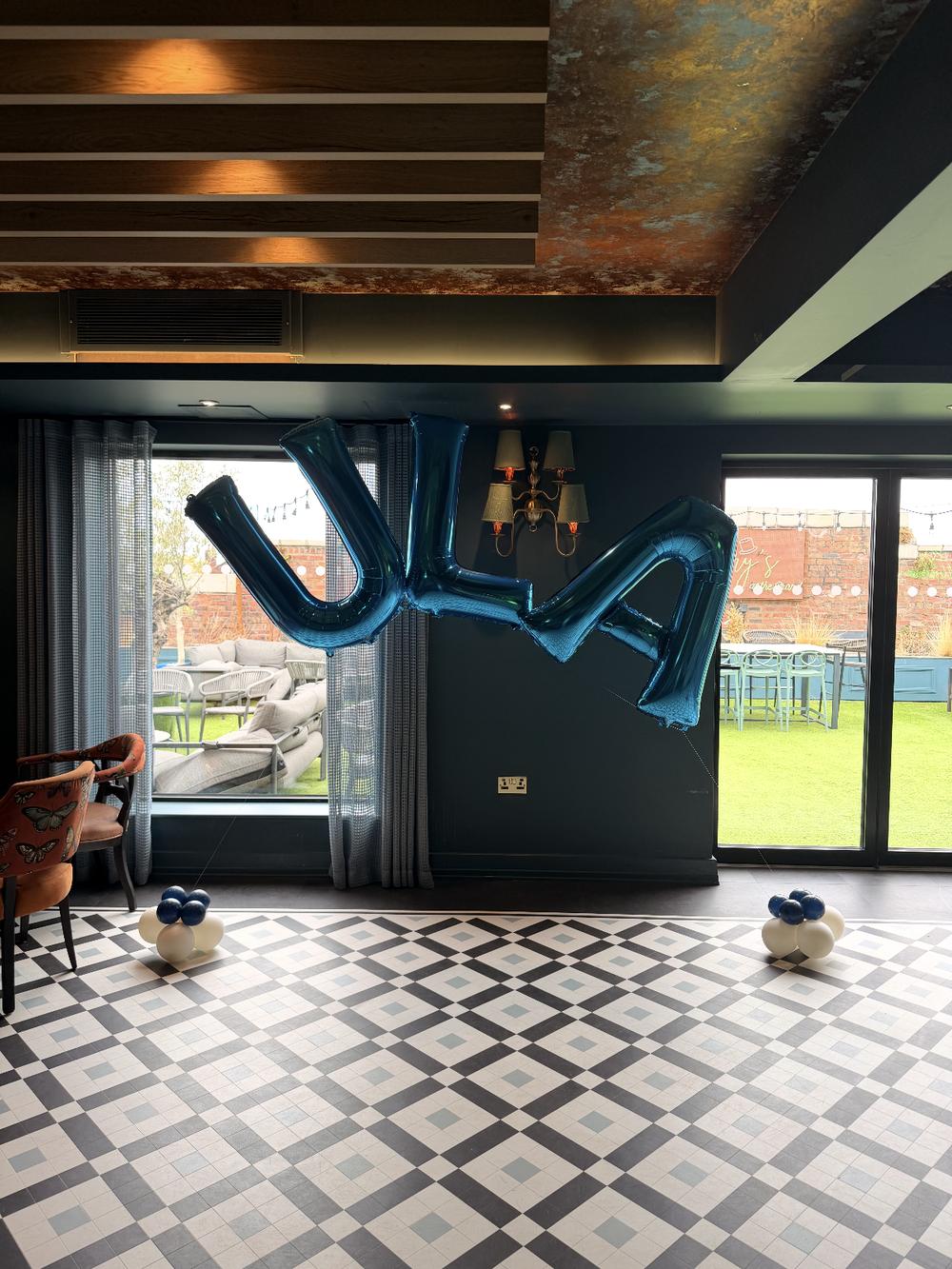 Large blue letter balloon display in a corporate venue
