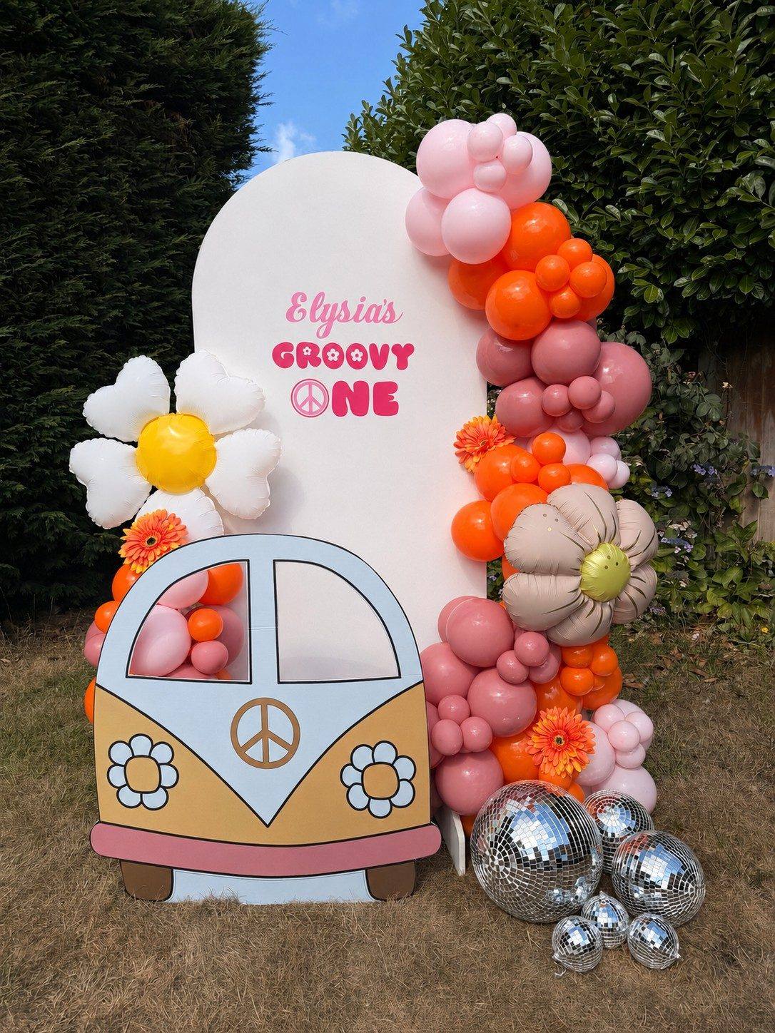 Retro-themed balloon display with disco balls for a first birthday party